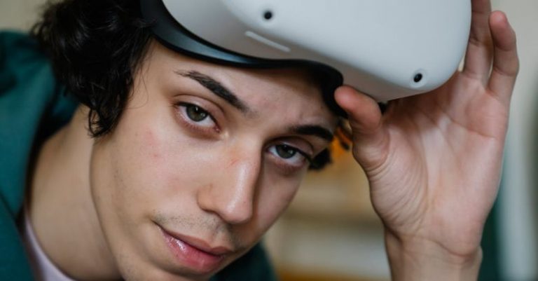 Cybersecurity Future - Young male gamer wearing VR headset for exploring cyberspace and playing video games looking at camera
