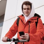 E-scooter - Pizza Deliveryman on a e-Scooter Reading a Text Message