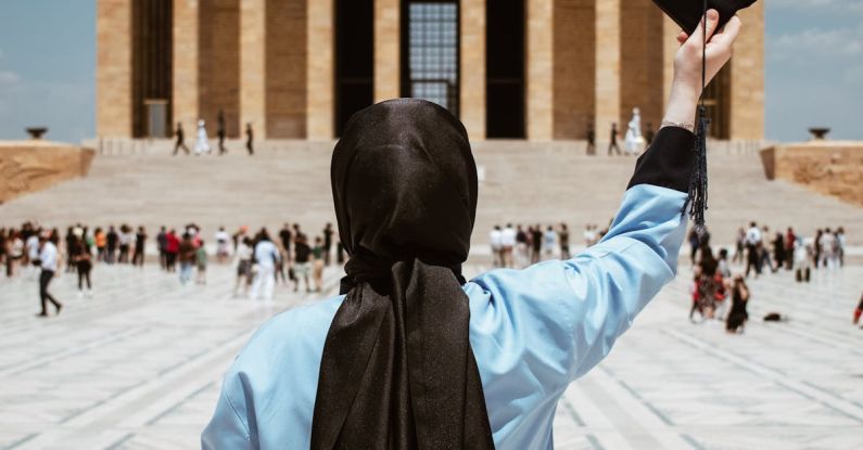 Microcredentials Education - A woman in a hijab holding a graduation cap