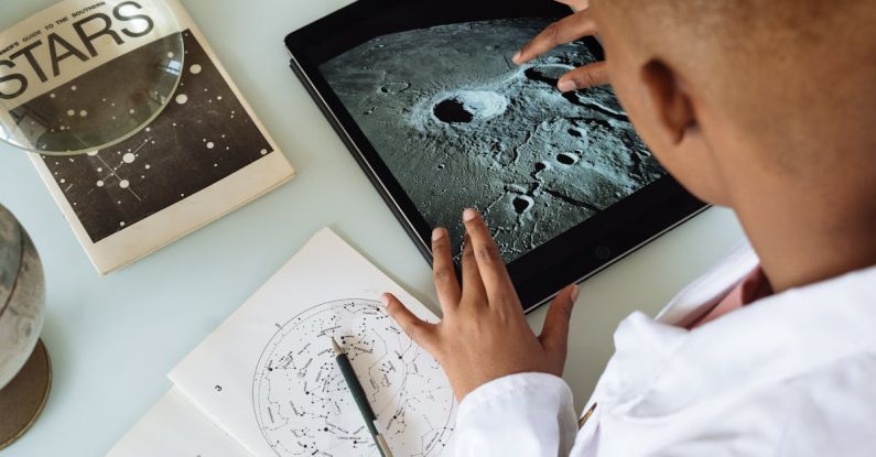 Data Healthcare - Crop African American student studying craters of moon on tablet at observatory