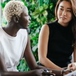 Smart Contracts - Diverse women talking about job while discussing contract and looking at each other in conference hall